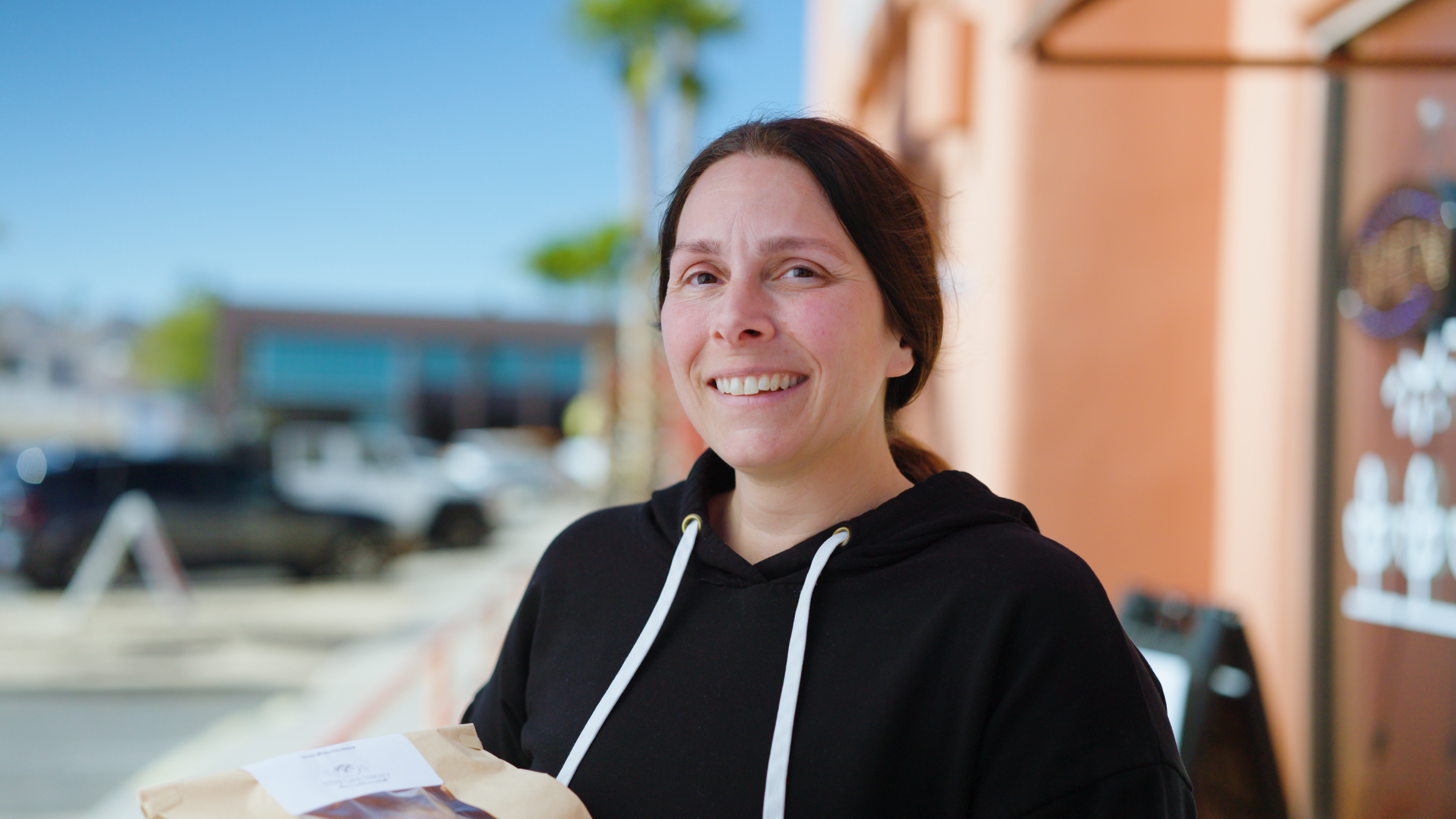 Woman holding a bag of food outdoors 
