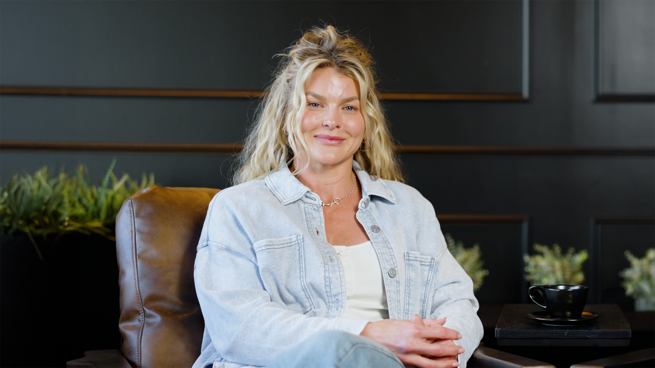 Woman sitting on a couch in a modern indoor setting