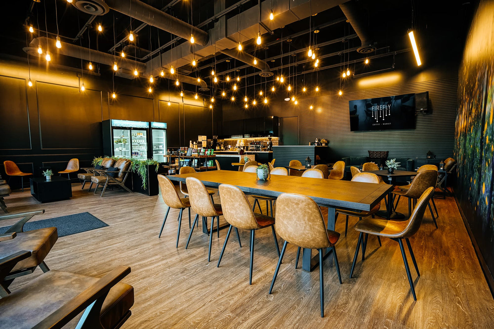 Modern restaurant interior with wooden tables and chairs, dim lighting, and a cozy atmosphere.