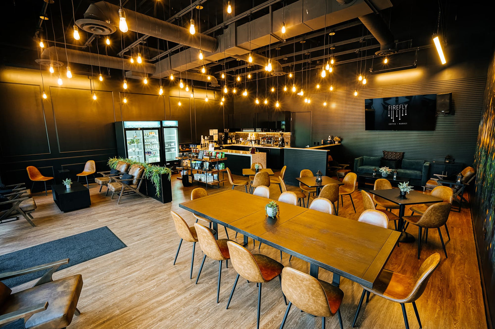 Modern restaurant interior with wooden tables and chairs, dim lighting, and decorative elements.