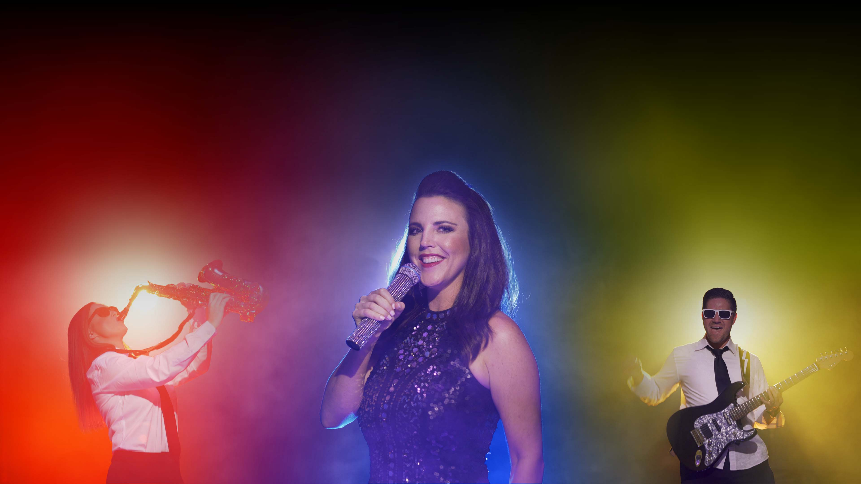 Singer performing on stage with colorful lights and musicians in the background