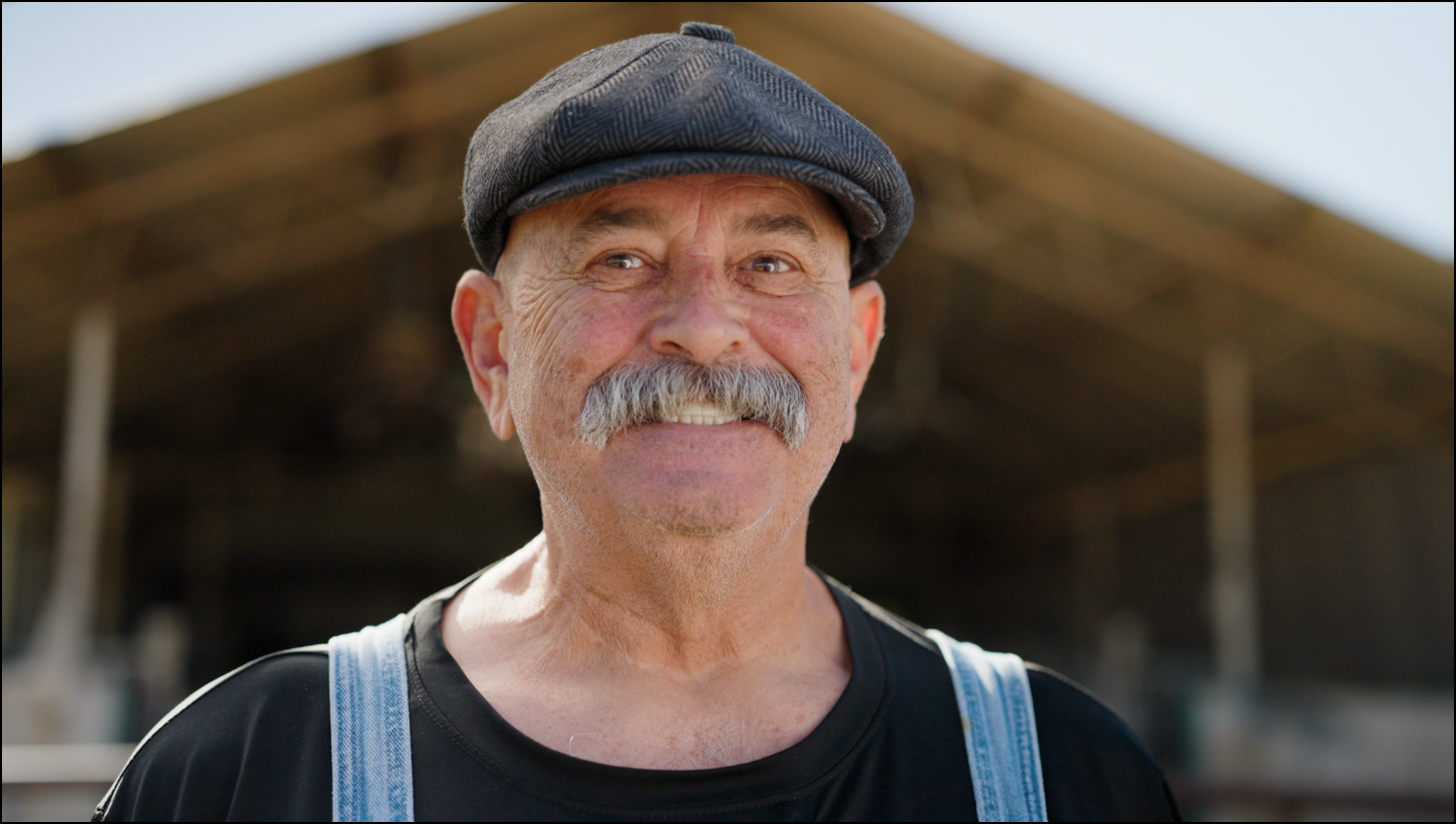 Man wearing a cap and overalls with a blurred background