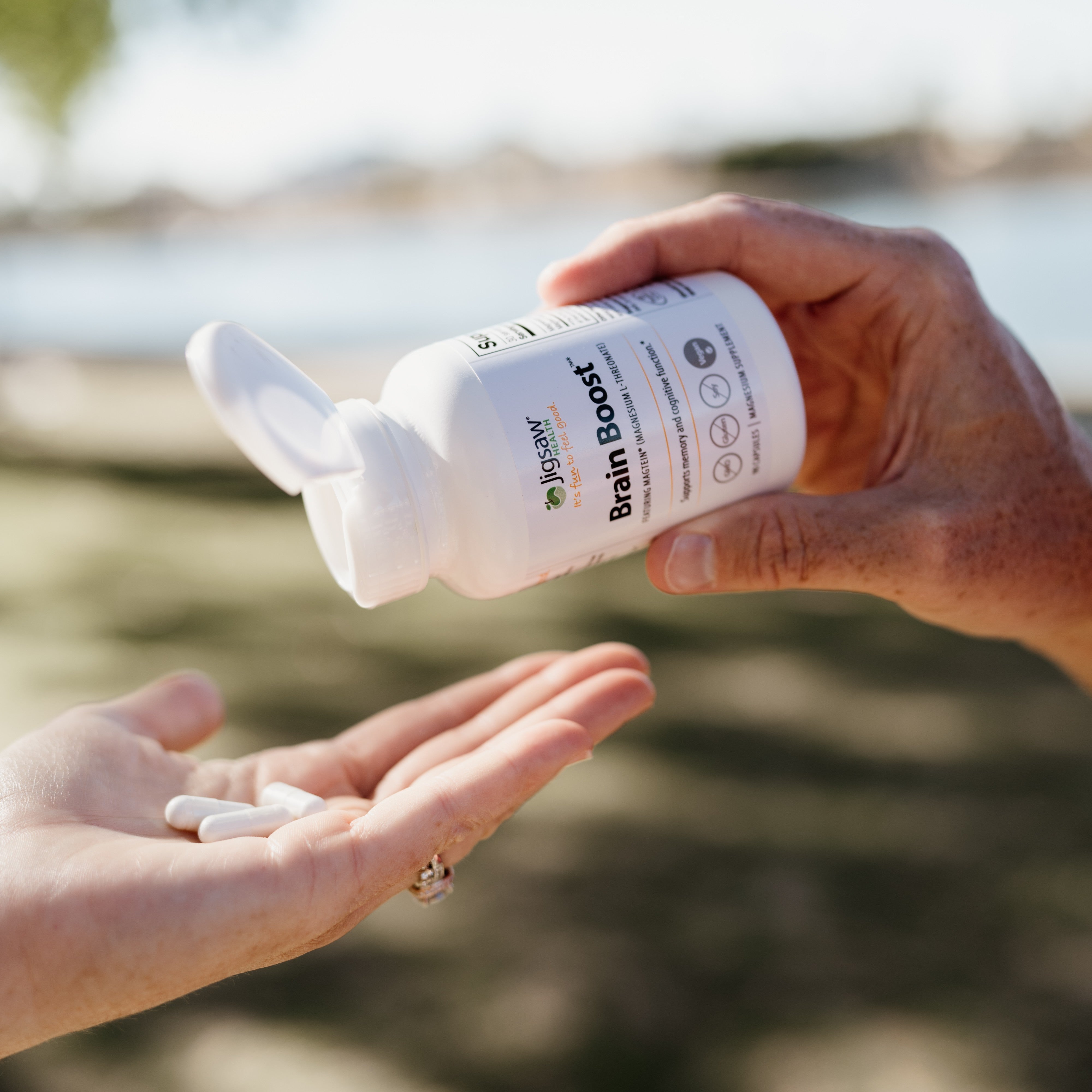 pouring Jigsaw Brain Boost pills into someones hand