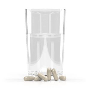 Jigsaw Adrenal Cocktail Capsules next to a glass of water