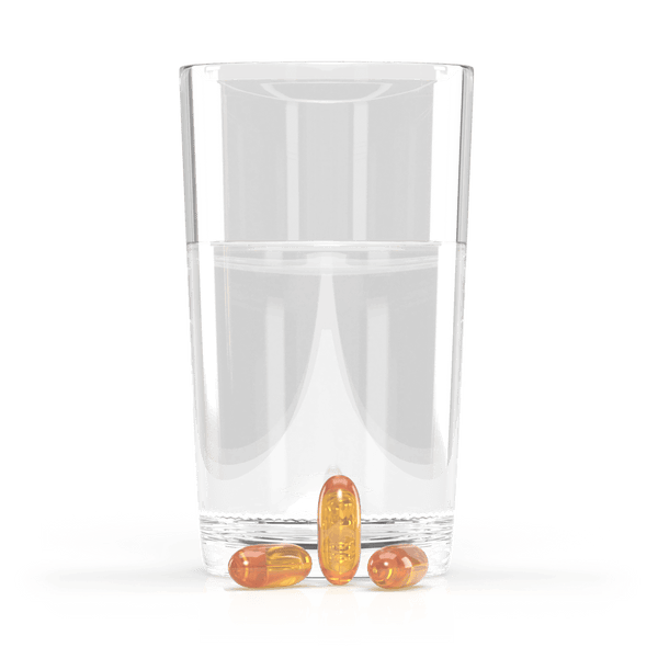 Jigsaw Alaskan Cod Liver Oil softgels next to a glass of water