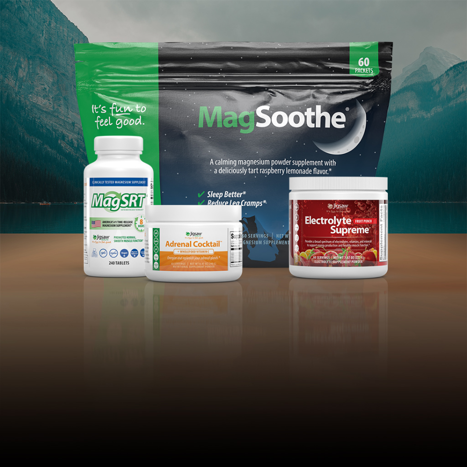 Collection of health and wellness products including bottles and containers on a reflective surface with a mountainous background.