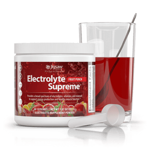 Jigsaw Electrolyte Supreme Fruit Punch jar and scoop next to a glass of water