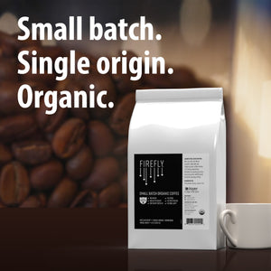 Firefly coffee bag with coffee beans and a cup in the background